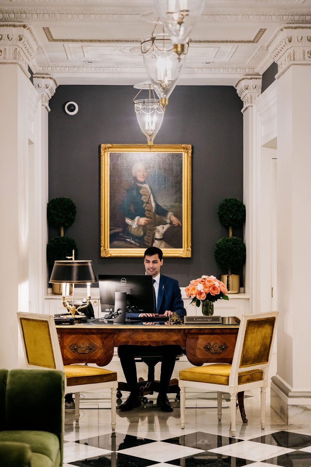 Concierge seated at desk in refined hotel lobby