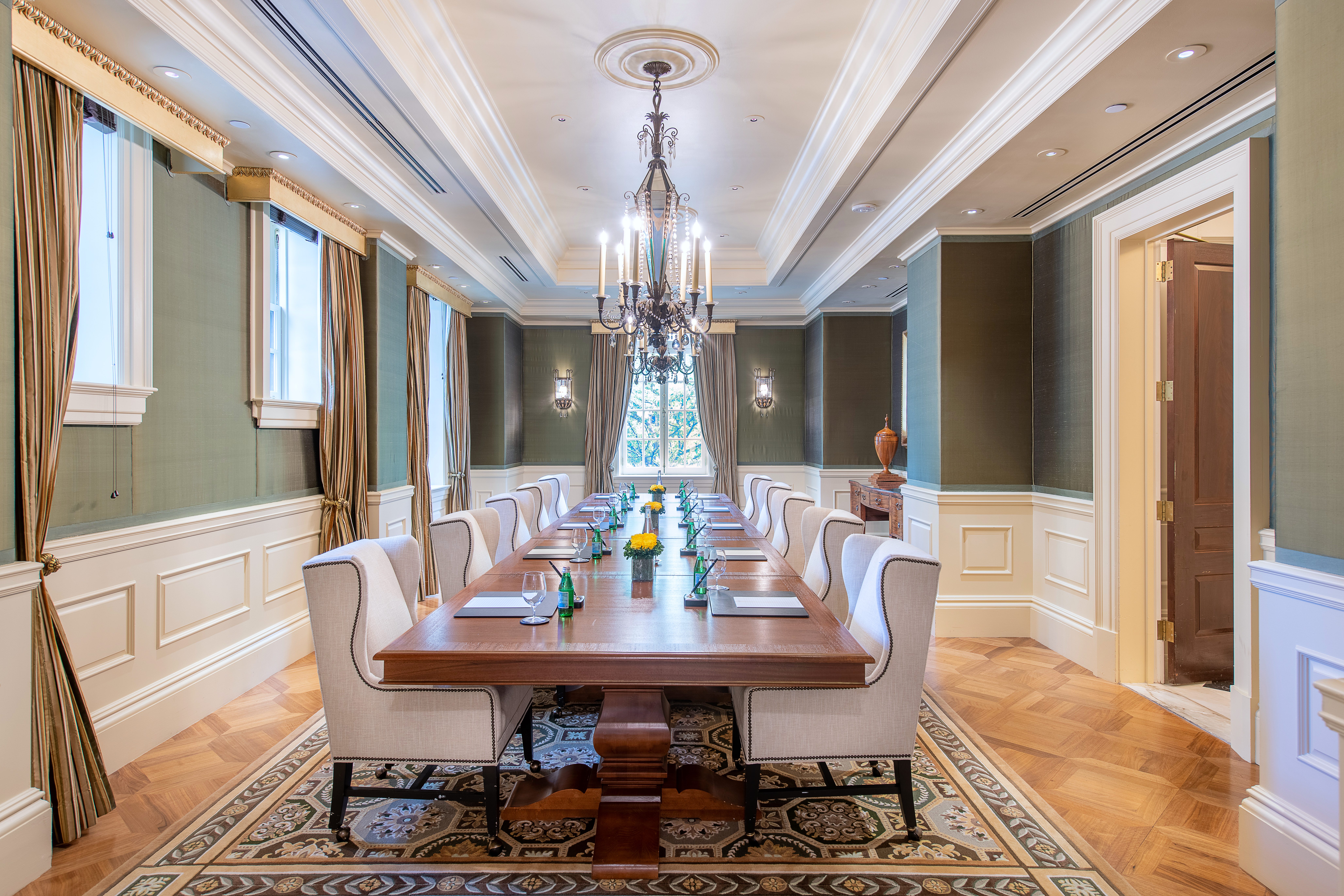Private meeting room with long table and chandelier