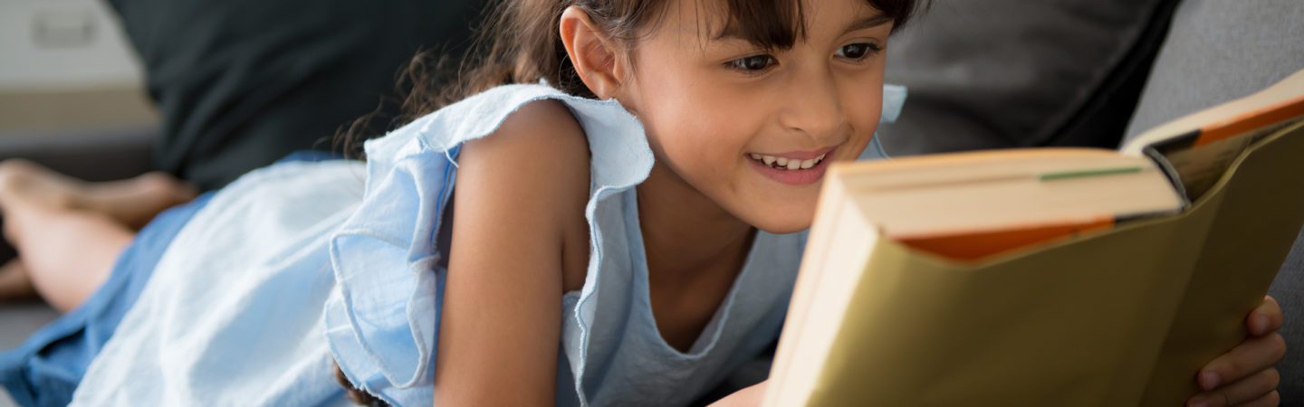 Little girl reading and smilling